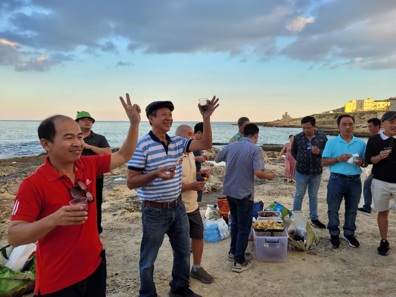 Các gia đình tổ chức dã ngoại, tiệc đứng BBQ tại bãi biển Malta vào chiều tối